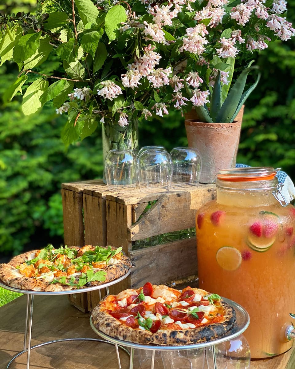 Wood-fired pizzas and lemonade on a garden table